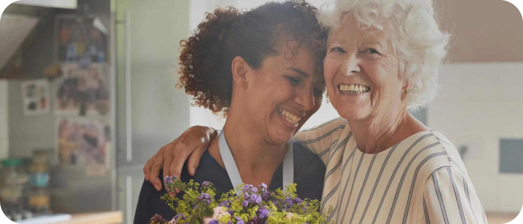 "Zwei Frauen lächeln sich an, was die Bedeutung mitfühlender Fürsorge für die peristomale Hautgesundheit widerspiegelt."