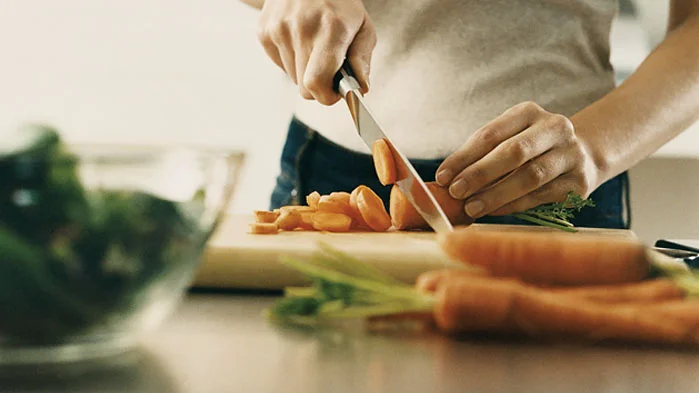 une personne qui coupe un sandwich